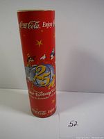 Red cylindrical metal tin featuring Disney characters and Coca-Cola branding for Walt Disney World's 25th Anniversary