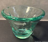 Front angled view showing the thick electric green blown glass bowl with curved rim and clear base.