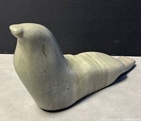 Front-side view showing detailed carving and rounded head of walrus sculpture with circular incised patterns on the body.