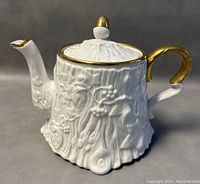 Front and side view of vintage Royal Stafford bone china teapot with tree bark texture and gold accent handle, spout tip, lid knob, and rim.