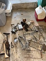 Wide view of vintage kitchen and hand tools on a concrete floor.
