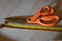 Top view showing entire length of scissors next to tape measure indicating approx. 10 inch length