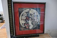 Framed lithograph print with red mat and abstract musicians in circular formation.