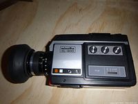 Angled front-left view of the Minolta XL-400 showing lens, brand logo, and control panel