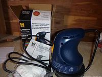 Wen 6010 polisher with cloth bonnets and instruction manual, in front of the product box