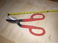 Full view of Wiss metal snips next to a tape measure showing length about 8 inches