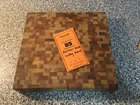 Top view of the butcher block cutting board with orange lot ticket on top describing the lot.