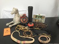 Full view of items on table including stone dog sculpture, necklaces, tea tins, and decorative pieces