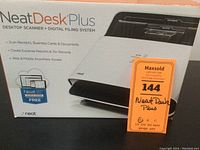Photo of the front side of the NeatDesk Plus product box showing the scanner image and features