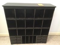 Front view of black painted wood sorter/organizer showing 15 cubbies and 6 small drawers at the bottom
