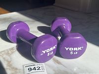 Photo of two purple hexagonal dumbbells with York 5 lb markings on marble surface.