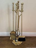 Full view of the brass fireplace tool set showing all 5 pieces on the stand