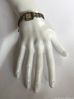 Photo showing the full watch on a display hand, highlighting the design and length of the sterling silver band with marcasite stones.