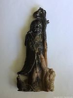 Front view of the carved soapstone Chinese figurine showing the detailed face, staff, and base.