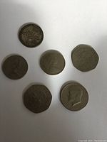 Top view of six coins showing various heads and animal designs, exhibiting surface wear