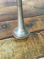 Close-up photo of brass bell showing 'London' marking and surface wear details