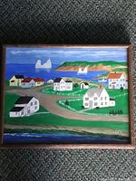 Full view of the framed pastel painting showing the whole coastal village scene with houses, water, and hills.