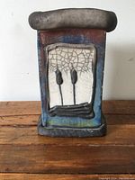 Front view of raku pottery vase showing willow design and crackled glaze panel.