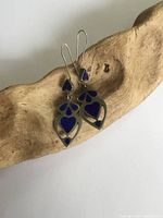 Front view of silver earrings with rich blue sodalite stones, showing design and color.