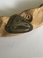 Front view of a triangular, Mexico sterling silver brooch with an abstract animal head design and visible tarnish and surface wear.