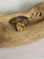 Top view of the sterling silver ring showing the yellow princess cut stone centrally set in the band.