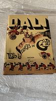 Cover of Salvador Dalí's Les Dîners de Gala vintage book showing surrealist artwork and title.