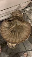 Top view of vintage clam shell oyster tray showing detailed shell ridges and decorative hinge area.