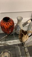 Photo of three vintage pottery vases on glass shelf, showing all items in the lot