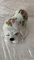 Front view of the ceramic puppy piggy bank with floral decorations