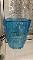 Front view of light blue Venini Murano glass wine cooler with white swirls, showing shape and handles.