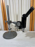 Microscope mounted on an adjustable stand showing full setup and base.