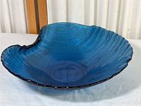 Full view of the blue art glass bowl showing its shape and texture