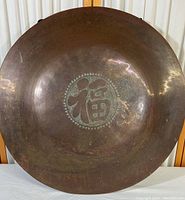 Full front view of the gong showing overall shape and central motif