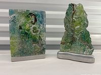 Front view of both sculptures side by side on aluminum bases