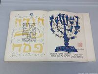 Open spread showing Hebrew text and gold-accented title page alongside blue mosaic-style menorah illustration