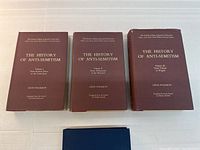 Front covers of the three volumes of The History of Anti-Semitism with brown covers and gold text.