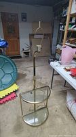 Full view of mid-century brass and glass floor lamp with demilune shelves