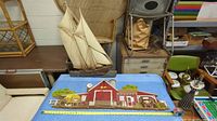 Burwood red barn country farm scene and Syroco sailboat wall hangings displayed on a table