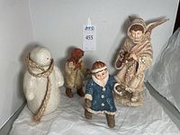 Overview of the four figurines: snowman, two children in winter clothing, and an angel figure.