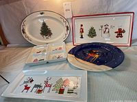Lot overview showing five Christmas-themed serving and decor plates featuring holiday designs including Christmas tree, nutcracker, snowman, gingerbread chef, reindeer, and divided sections.