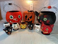 The full set of Halloween themed papier mâché treat baskets displayed on a surface, showcasing various designs.