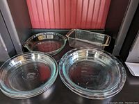 Overview photo showing all six baking dishes including the three 8-inch simple pie dishes, two 9.5-inch fluted edge pie dishes, one handled 9.5-inch pie dish, and rectangular bread dish.