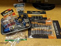 Photo of various battery packs from Duracell and Energizer including AA, AAA, 9V, and loose C and D size batteries.