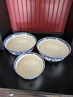 Front view of three ceramic bowls featuring blue rooster design and floral border, sized 10", 8.5", 6" approximately