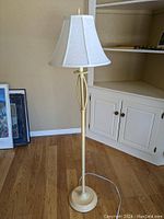 Full view of standing floor lamp with cream crackle finish and white fabric shade in a room setting.