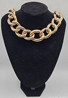 Front view of heavy gold-tone chain choker displayed on black bust form