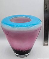 Photo of large art glass vase showing size with a ruler indicating 8.75 inches height, with blue rim, pink midsection, and dark base.