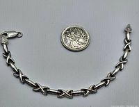 Full view of silver bracelet beside a Canadian quarter for scale.