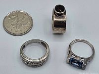Three sterling silver rings displayed with a Canadian 25 cent coin for size reference