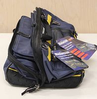 Side view of the navy blue and black Mastercraft compressible tool bag with labels attached, showing its structure and compression feature